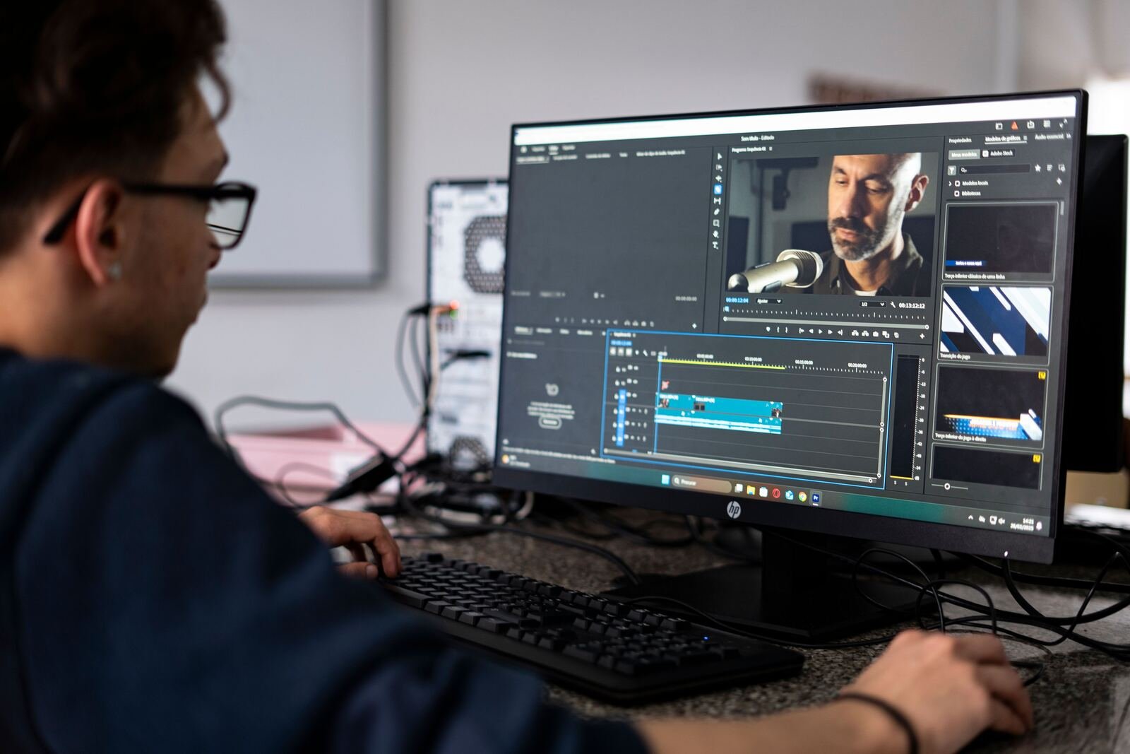 Editor reviewing a video project at a desktop computer